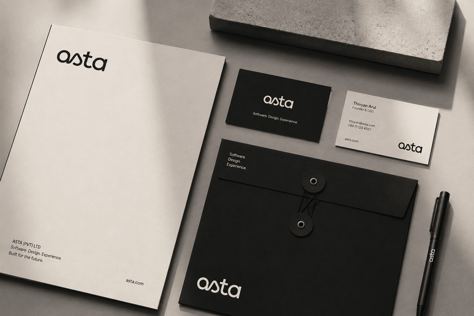 Asta stationery, letterhead and business cards in black and off white beside a string-tie envelope carrying the line “Software. Design. Experience.”