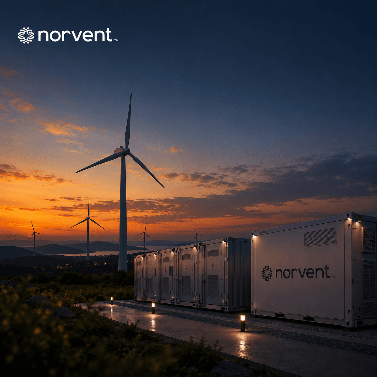 Branded battery storage units beside a turbine at dusk